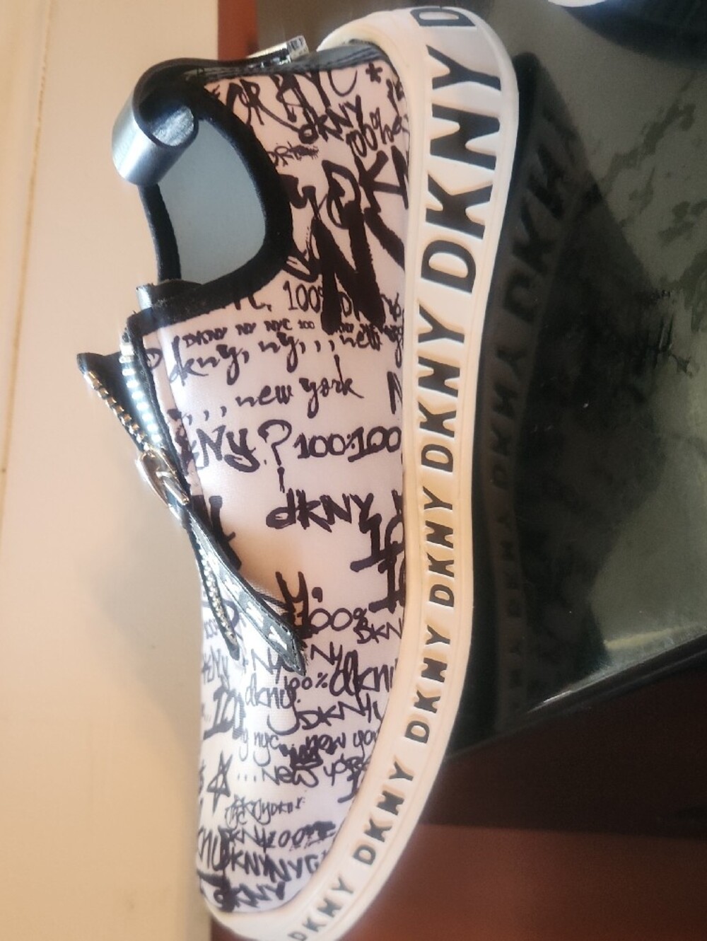 DKNY White and Black Graffiti Zip-Front Slip-On Sneakers with Branded Pull - Picture 2 of 5